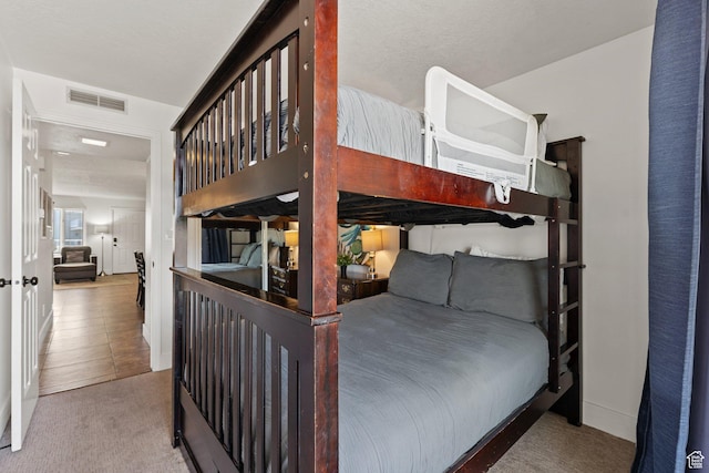 carpeted bedroom featuring visible vents