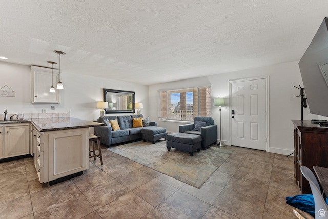 tiled living area with a sink and a textured ceiling
