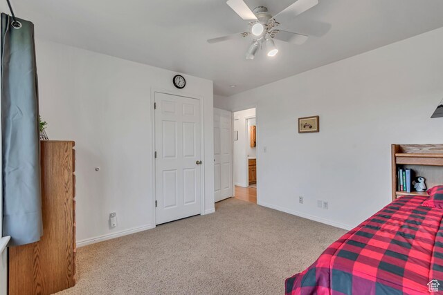 carpeted bedroom with a ceiling fan and baseboards