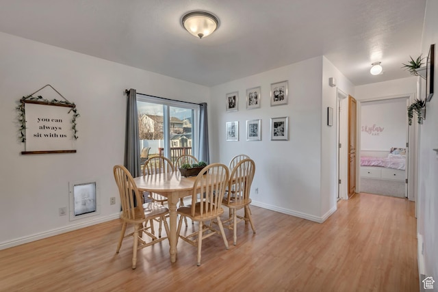 dining area featuring baseboards and light wood finished floors