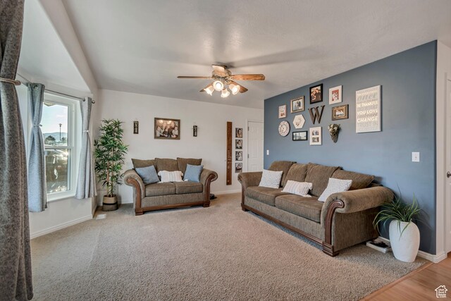 living room with baseboards and ceiling fan