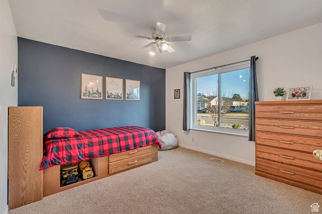 carpeted bedroom with baseboards, visible vents, and a ceiling fan
