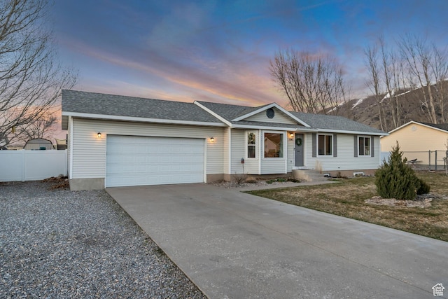 ranch-style home featuring driveway, an attached garage, fence, and roof with shingles