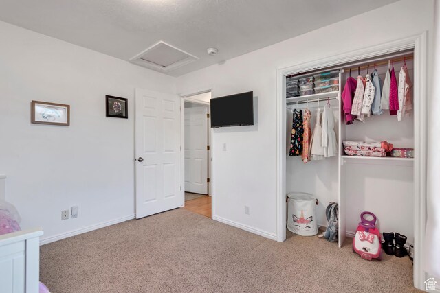 carpeted bedroom featuring baseboards and attic access