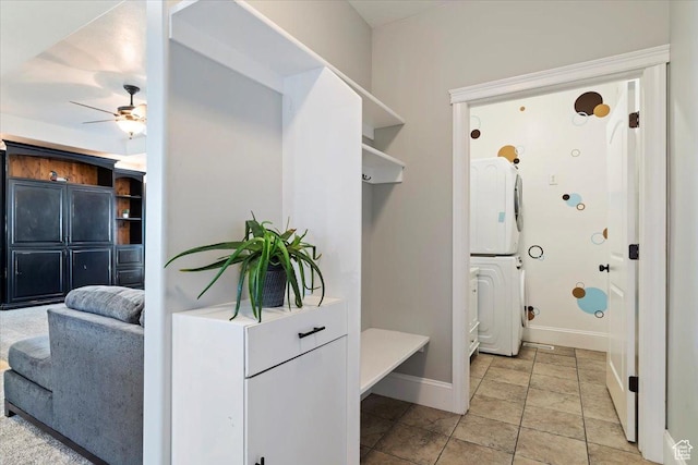 mudroom featuring stacked washer / dryer, baseboards, and ceiling fan