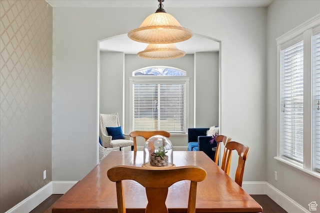 dining space featuring plenty of natural light, dark wood-type flooring, and baseboards