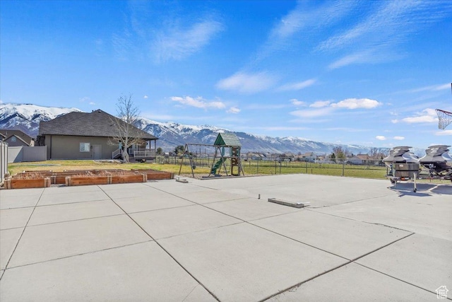 view of patio / terrace with a garden, a mountain view, and fence