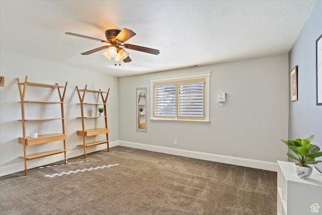 carpeted empty room featuring baseboards, a textured ceiling, and ceiling fan