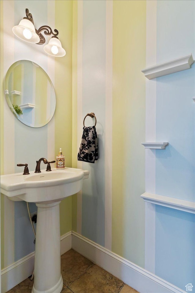 bathroom with tile patterned flooring, a sink, and baseboards