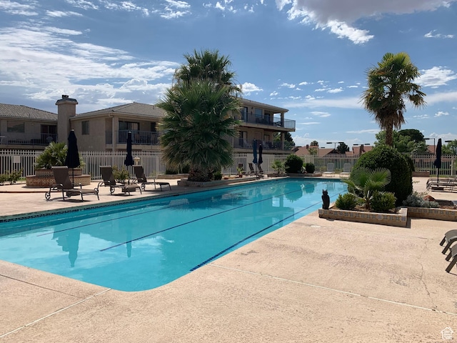community pool with fence and a patio