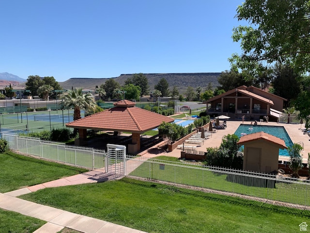surrounding community featuring a mountain view, a gazebo, fence, and a yard