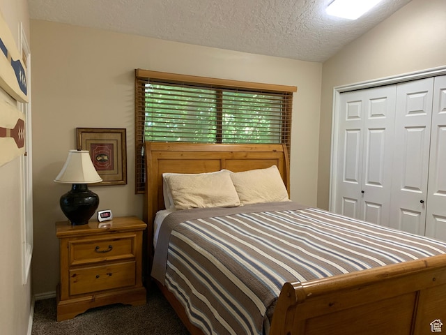 carpeted bedroom with a closet and a textured ceiling