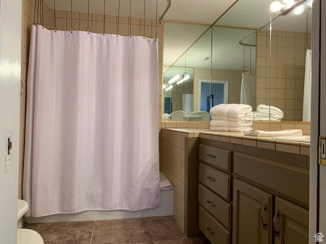 bathroom with shower / bath combination with curtain, toilet, vanity, and tile patterned flooring