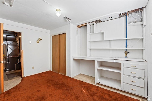 unfurnished office featuring heating unit, visible vents, and carpet
