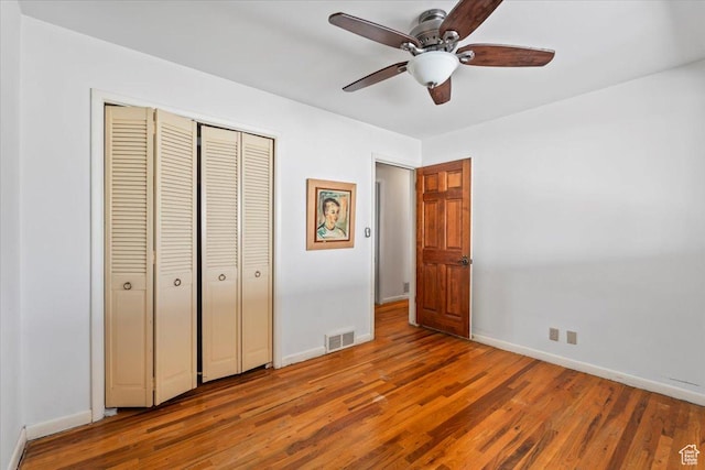 unfurnished bedroom with baseboards, visible vents, and wood finished floors