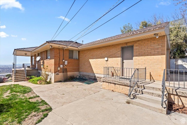 exterior space with fence, a patio, and brick siding