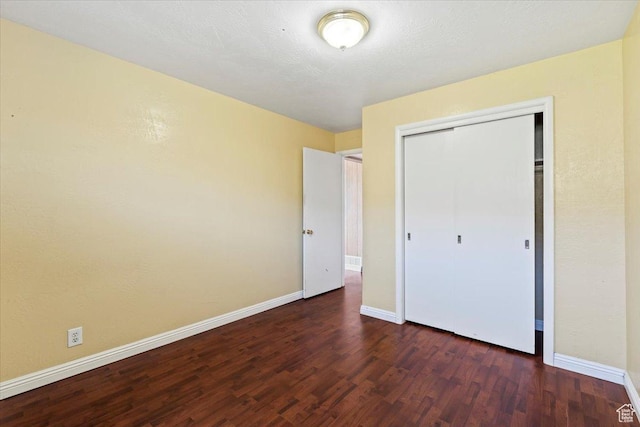 unfurnished bedroom with baseboards, a closet, and wood finished floors