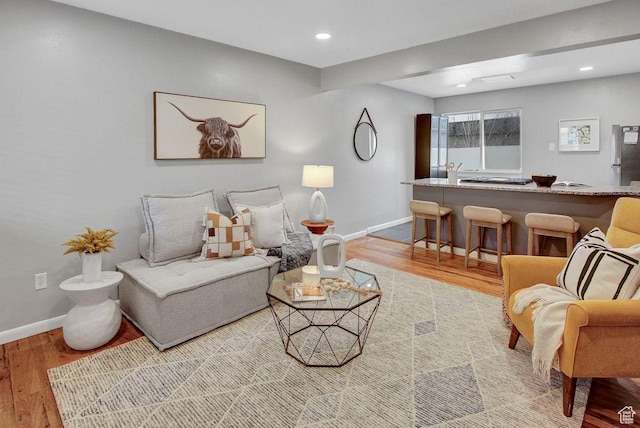 living room with recessed lighting, baseboards, and wood finished floors