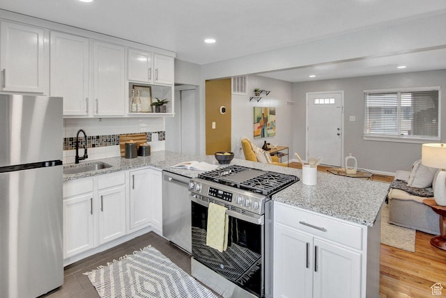 650 N 300 W Unit 202, Salt Lake City, UT 84103 - kitchen with white cabinetry, stainless steel appliances, a sink, visible vents, and a peninsula