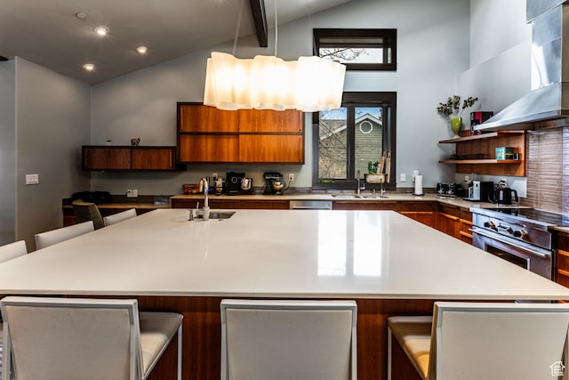 kitchen with wall chimney exhaust hood, high end stainless steel range, a sink, modern cabinets, and brown cabinets