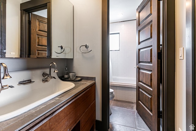 bathroom featuring toilet, tile patterned flooring, vanity, and shower / bathtub combination