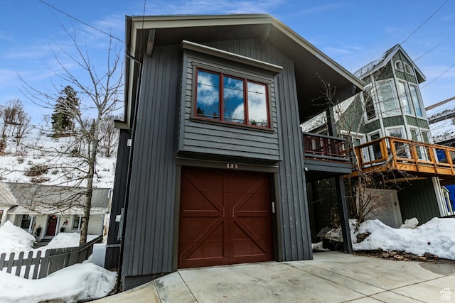 view of front of house with a wooden deck, driveway, and an attached garage