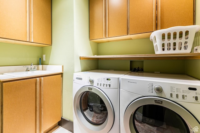 clothes washing area featuring independent washer and dryer, cabinet space, and a sink
