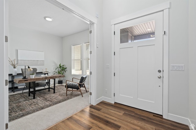 foyer entrance featuring dark wood-style floors and baseboards