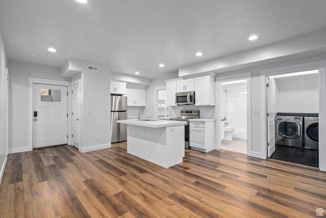 kitchen featuring dark wood finished floors, separate washer and dryer, visible vents, and appliances with stainless steel finishes