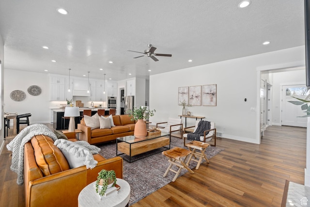 living room featuring recessed lighting, a textured ceiling, ceiling fan, and wood finished floors