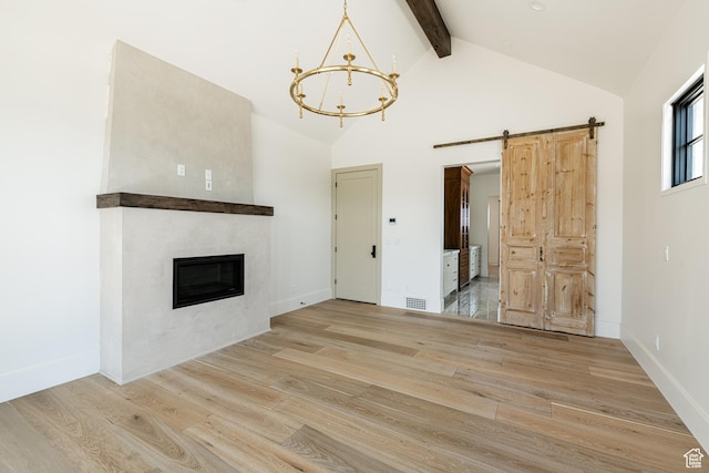 131 S Meadow Dr Unit 20, Springville, UT 84663 - unfurnished living room featuring beam ceiling, a barn door, visible vents, light wood-style floors, and an inviting chandelier