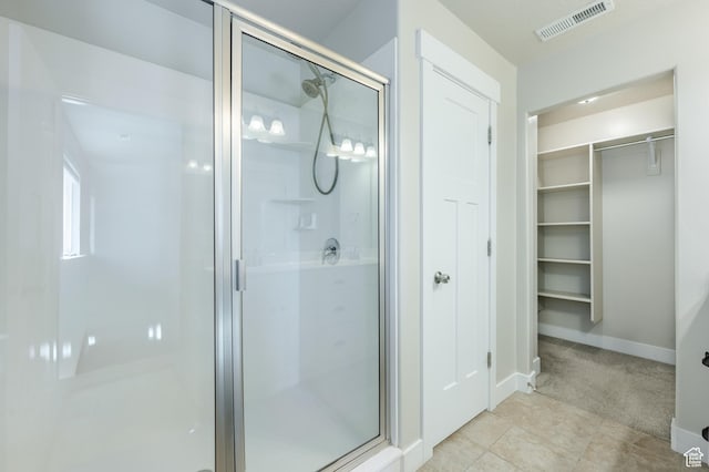 607 N Glenwilde Rd Unit 116, Vineyard, UT 84059 - bathroom featuring tile patterned floors, a shower stall, a spacious closet, baseboards, and visible vents