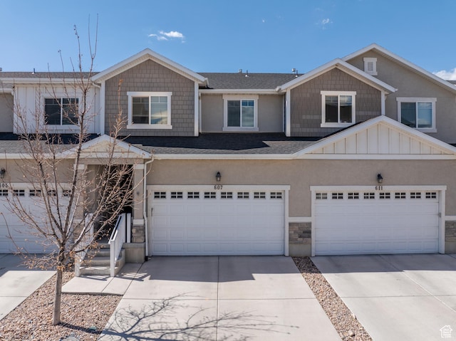 view of front of home with stone siding, concrete driveway, stucco siding, a shingled roof, and a garage