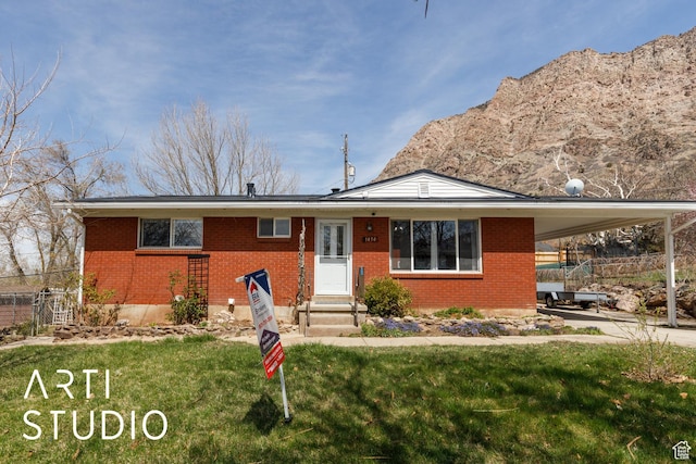1454 E Harrop St, Ogden, UT 84404 - ranch-style home with a carport, entry steps, a front yard, fence, and brick siding