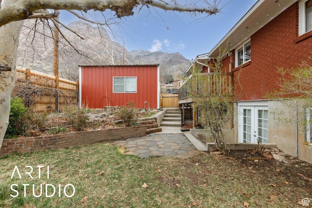 1454 E Harrop St, Ogden, UT 84404 - exterior space with an outbuilding, a deck with mountain view, fence, stairs, and french doors