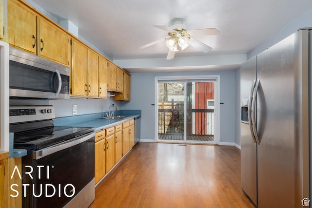 1454 E Harrop St, Ogden, UT 84404 - kitchen featuring light wood-type flooring, a ceiling fan, a sink, stainless steel appliances, and baseboards