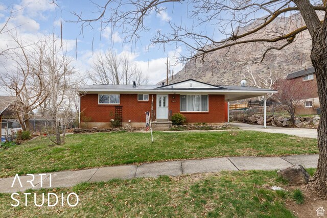 1454 E Harrop St, Ogden, UT 84404 - view of front facade featuring a carport, a front lawn, brick siding, and concrete driveway