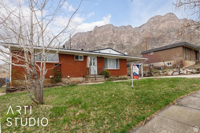 1454 E Harrop St, Ogden, UT 84404 - view of front of property with brick siding, a mountain view, and a front lawn