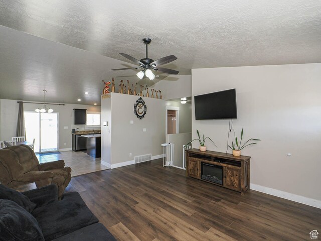 2291 E Ox Yoke Dr N, Eagle Mountain, UT 84005 - living room with lofted ceiling, ceiling fan with notable chandelier, a textured ceiling, visible vents, and wood finished floors