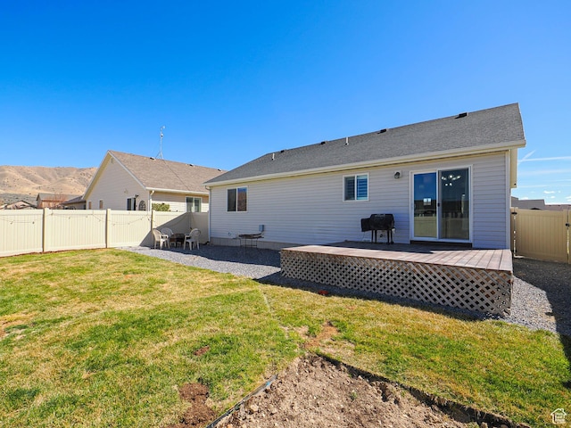 2291 E Ox Yoke Dr N, Eagle Mountain, UT 84005 - rear view of house featuring a fenced backyard, a lawn, a wooden deck, and a patio area