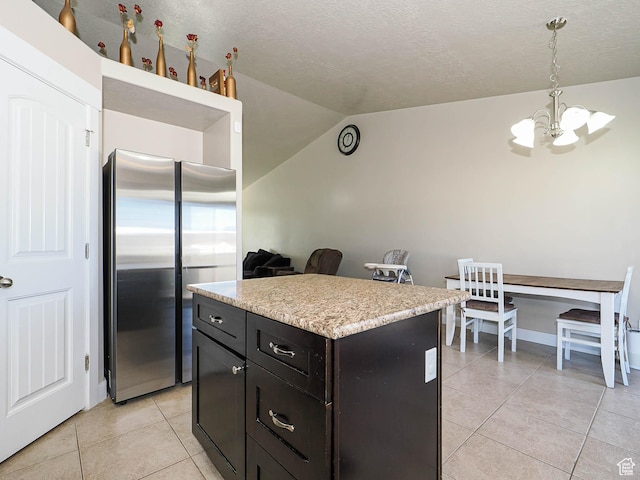 2291 E Ox Yoke Dr N, Eagle Mountain, UT 84005 - kitchen with light countertops, lofted ceiling, an inviting chandelier, light tile patterned floors, and freestanding refrigerator