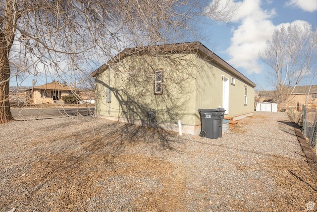rear view of property with an outbuilding and a storage shed