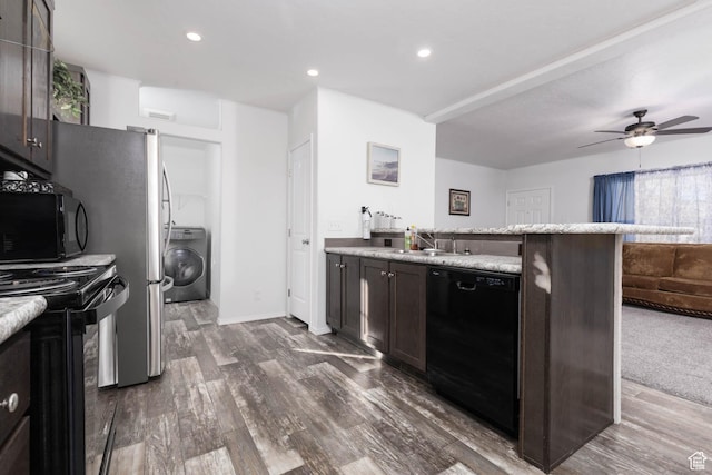 kitchen with dark wood finished floors, a sink, washer / dryer, a ceiling fan, and black appliances