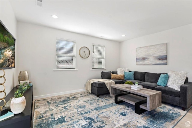 living area featuring baseboards, visible vents, and recessed lighting