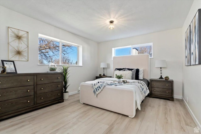bedroom featuring light wood-style flooring and baseboards