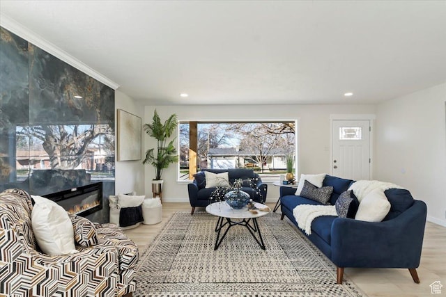 living room with a fireplace, baseboards, light wood finished floors, and recessed lighting