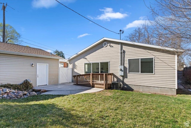 rear view of house featuring a gate, a deck, a patio, and a yard