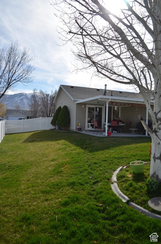 5451 N Heather Way W, Stansbury Park, UT 84074 - rear view of house with fence, a mountain view, a yard, and a patio area
