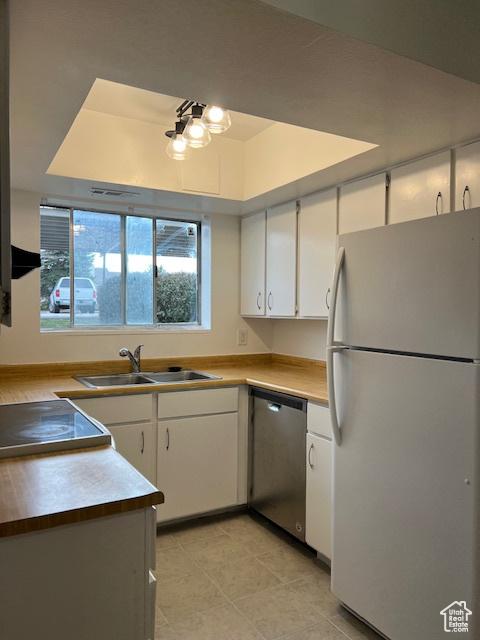 1042 E Quail Vista Ct Unit A, Millcreek, UT 84117 - kitchen featuring light countertops, a sink, a raised ceiling, white cabinetry, and appliances with stainless steel finishes