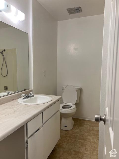 1042 E Quail Vista Ct Unit A, Millcreek, UT 84117 - full bath with baseboards, visible vents, toilet, and vanity